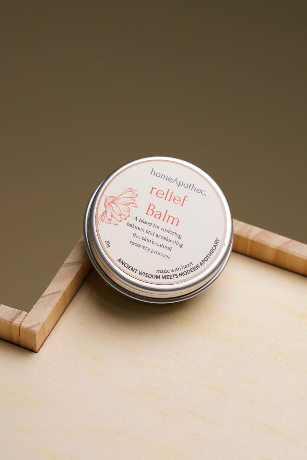 Relief Balm tin on a pale wooden tray